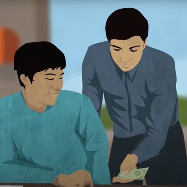A man paying another wages with cash